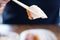 Sliced crispy pork belly or deep fried pork holded by chopsticks with blurred background