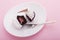 Sliced cupcake on a white plate, a fork lies next to it, on a pink background, holiday concept