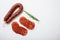 Sliced cuts of chorizo salami sausage on white textured background with space for text
