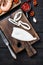 Sliced cuttlefish on wooden board over black wood table, flat lay