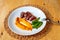 Sliced deer steak,pumpkin puree, pea pods on white plate