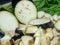 Sliced eggplant on a cutting board. Cutting vegetables. Healthy diet. Eggplant with cilantro and parsley on the table. Garlic