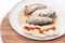 Sliced eggs with tomato ketchup and sardines served on the plate