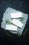 Sliced feta cheese with rosemary on rustic paper