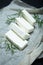Sliced feta cheese with rosemary on the table