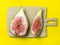 sliced figs on a cutting board. Juicy ripe fruit on a yellow background. Diet food. Fig isolate. Seeds inside. Bright picture