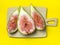 sliced figs on a cutting board. Juicy ripe fruit on a yellow background. Diet food. Fig isolate. Seeds inside. Bright picture