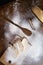 Sliced French baguette on a wooden board  cinnamon sticks and a trail of a large spoon  heavily floured on a wooden table