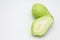 Sliced fresh Chayote and half on white.