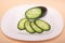 Sliced fresh cucumbers on a white plate. chopped greenngherkins closeupn