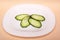 Sliced fresh cucumbers on a white plate.chopped ngherkins n