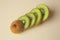 Sliced fresh kiwi on beige background, above view