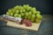 Sliced Fuet sausage and grapes on wooden board