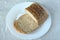 Sliced grain bread with sesame on white plate on gray table cloth