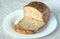 Sliced grain bread on white plate on gray table cloth