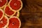 Sliced grapefruits on wooden table. Top view, copy space