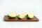 Sliced green crystal guava raw fruit on a wooden plate isolated on a white background