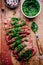 Sliced grilled barbecue beef steak with green chimichurri sauce