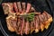 Sliced Grilled Florentine steak. T bone meat beef. Black background. Top view