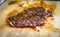 Sliced grilled juicy marinated beef flank steak on wooden board