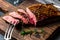 Sliced grilled medium rare beef steak served on wooden board Barbecue, bbq meat beef tenderloin. Top view, slate