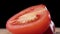 Sliced half ripe red tomato close-up on a wooden cutting board.