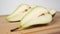 Sliced in half sweet juicy conference pear close-up on a wooden brown cutting board.