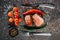 Sliced halved lean piece of seared steak on the table, next to which are cutlery fork and knife, as well as a sprig of cherry