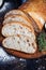 Sliced homemade italian ciabatta bread with olive oil on dark background. Ciabatta, herbs, olive oil, flour. Close up view, copy s