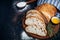 Sliced homemade italian ciabatta bread with olive oil on dark background. Ciabatta, herbs, olive oil, flour. Close up view, copy s