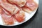 Sliced jamon hamon or prosciutto on a wooden background