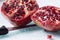 Sliced juicy pomegranate with knife
