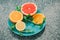 Sliced lemon, orange, grapefruit and mint on a blue plate, vitamins, citrus in minimalism style, pop art