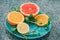 Sliced lemon, orange, grapefruit and mint on a blue plate, vitamins, citrus in minimalism style, pop art