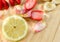 Sliced lemon, strawberries, banana and rose-petals on wooden board