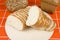 Sliced loaf of bread  on a wooden tray. Composition of bakery products.