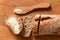 Sliced loaf of whole wheat european bread on light wood. Buttered slice and wood knife. Top view