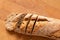 Sliced loaf of whole wheat european bread on light wood. Top view. Space for text