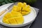 Sliced mango fruit on a white round plate ready to be served. Top view, healthy fruit breakfast or snack