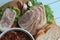 Sliced meatloaf lying on a green salad with slices of bread