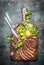 Sliced medium rare grilled beef barbecue steak served with fresh green salad and cutlery on rustic cutting board , top view.