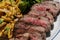 Sliced medium rare steak with pasta and salad