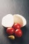 Sliced mozarella ball with tomato and olives on slate background