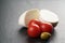 Sliced mozarella ball with tomato and olives on slate background