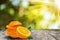 Sliced orange fruit with leaves on wooden table  with sunray and shinny bokeh background