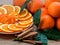 Sliced orange with spiral zest on the plate and groupe of oranges on the wooden table