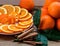 Sliced orange with spiral zest on the plate and groupe of oranges on the wooden table