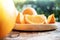 Sliced Orange on Wooden Plate. Fresh Juicy Fruit in Summer. Selective Focus. Blurred Tree with Lens Flare