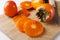 Sliced persimmon on the cutting board. Raw sweet and tasty persimmons