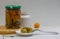 Sliced pickled cucumber on a white plate with a fork. Canned vegetables and a white can in the light background.